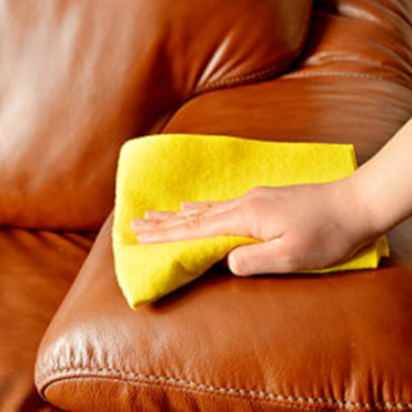 hand with cloth on leather sofa