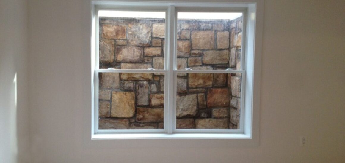 Window looking into stone wall
