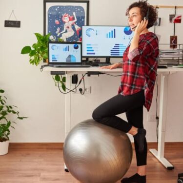 Woman with yoga ball in front of Standing Desk